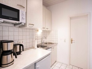 A compact kitchen with a microwave, kettle, and sink. - Holiday Apartment With 1 Bedroom (Heringsdorf)