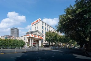 Un edificio con fachada clásica, una entrada destacada y un letrero con caracteres chinos.