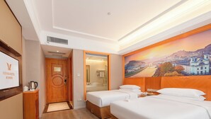 Una habitación de hotel con una cama, un escritorio y un televisor.
