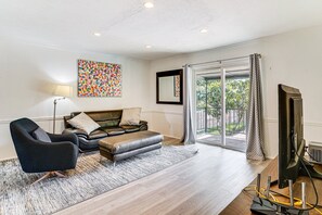 A living room with a sofa, armchair, and a flat-screen TV. - Private 1-bedroom condo with AC in vibrant Dallas Pool Wifi Washer& Dryer (Dallas)