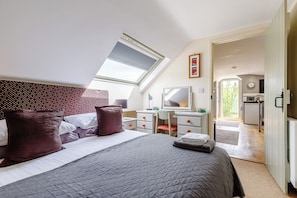 A bedroom with a bed, a desk, a chair, a mirror, and a skylight. - Viewpoint Studio | Shropshire Countryside Stay (Stretton Westwood)
