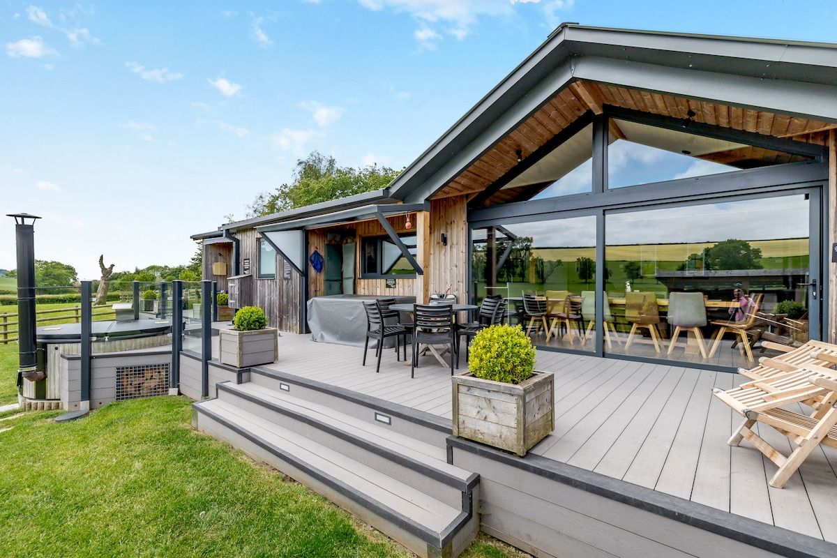 Eine moderne Außenpatio mit Holzterrasse, Sitzgelegenheiten im Freien und einer großen Glaswand.