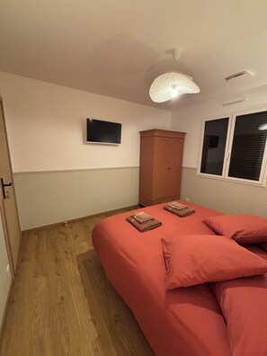 A bedroom with a bed, a wardrobe, a television, and a window. - Charming vacation rental (Cublac)