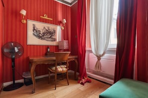 A room with a desk, chair, fan, and a window with red curtains. - A comfortable 65 sqm flat that sleeps up to 4 people, located on the 4th floor of a building with an elevator (though there are stairs to reach the entrance).The property is situated in the Piazza Cinque Giornate-Corso XXII Marzo area, a well served resi (Milan)