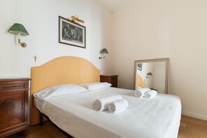 A hotel room with a bed, a wooden dresser, a green wall lamp, a framed picture, and a mirror. - A comfortable 65 sqm flat that sleeps up to 4 people, located on the 4th floor of a building with an elevator (though there are stairs to reach the entrance).The property is situated in the Piazza Cinque Giornate-Corso XXII Marzo area, a well served resi (Milan)