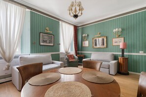 A room with a round wooden table, two white sofas, and a green-striped wall. - A comfortable 65 sqm flat that sleeps up to 4 people, located on the 4th floor of a building with an elevator (though there are stairs to reach the entrance).The property is situated in the Piazza Cinque Giornate-Corso XXII Marzo area, a well served resi (Milan)