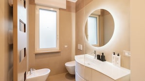 A modern bathroom with a bidet, toilet, and a large mirror. - Residenza De Nicolis - 50mt Piazza Erbe (Verona)