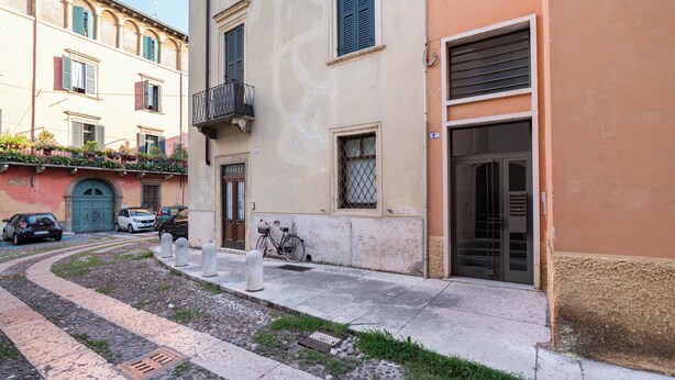 A narrow street with buildings, a bicycle, and parked cars. - Residenza De Nicolis - 50mt Piazza Erbe (Verona)