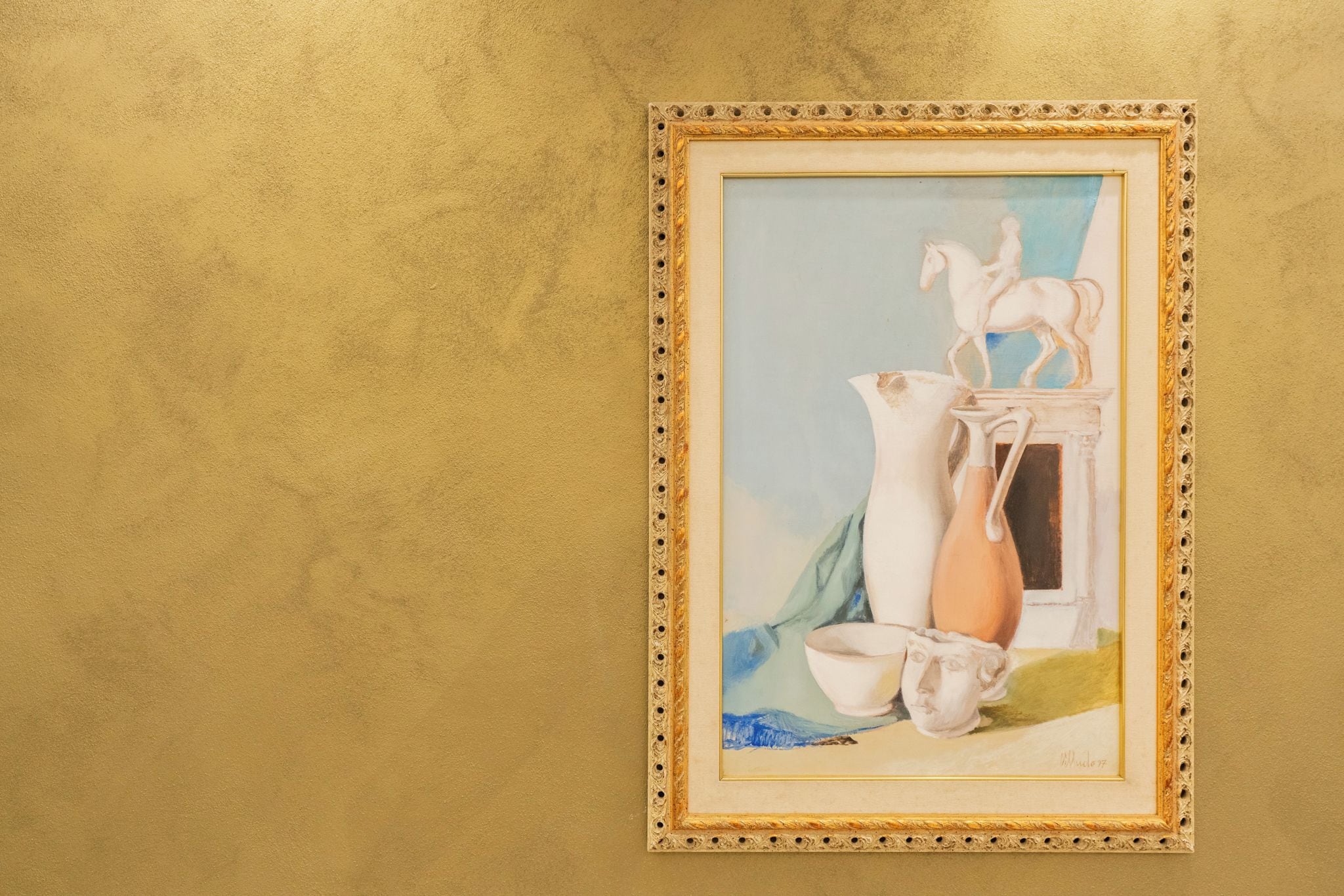 A framed artwork with a classical theme, including a horse and classical architecture elements, displayed on a textured wall.
