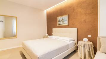 Un dormitorio con una cama, una mesita de noche, un espejo y un cuadro en la pared.
