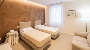 A hotel room with two beds, a sofa, a lamp, a painting, and a view of the outdoors. - Residenza De Nicolis - 50mt Piazza Erbe (Verona)