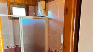 A small bathroom with a toilet, a sink, and a shower enclosure. - Arzum Bungalovs (KUMLUCA)