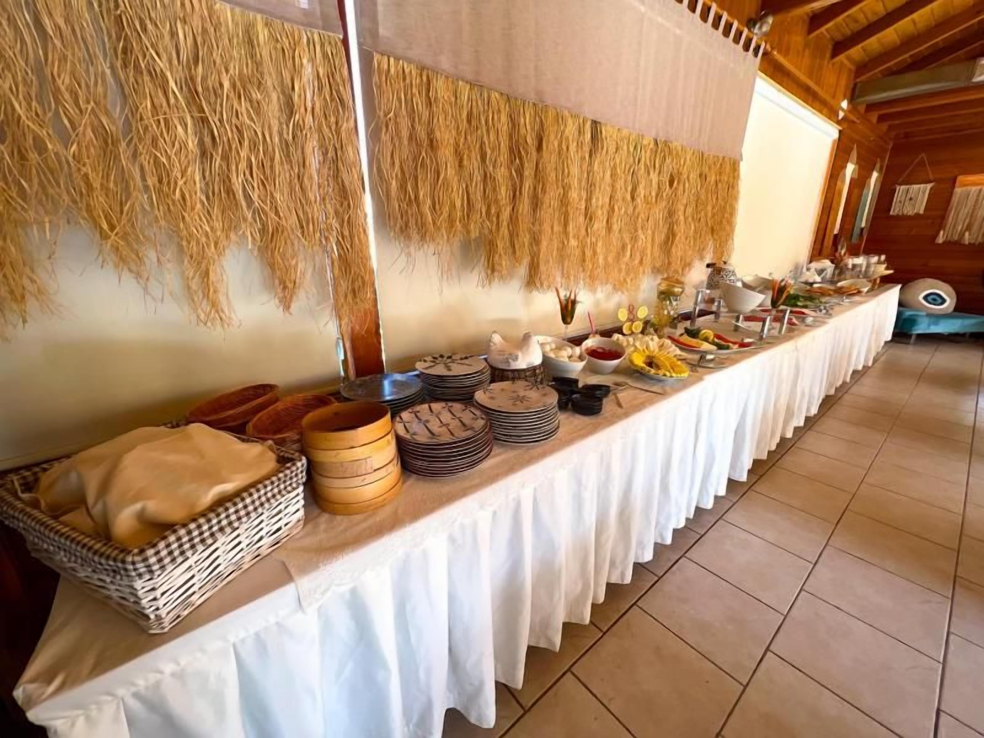 Ein Buffet mit verschiedenen Speisen und einem gewebten Wandbehang.