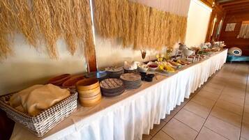Una mesa de buffet con diversos alimentos y un tapiz tejido.