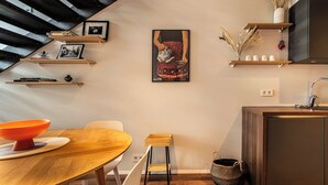 A modern kitchen with wooden shelves, a dining table, and a staircase. - SIF Apartments Reykjavik - Two Floors 1 Bedroom (Reykjavík)