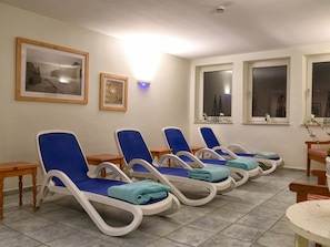 A room with multiple sun loungers, a framed picture, and a window with a view. - Holiday Apartment With 1 Bedroom (Wyk auf Foehr)