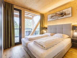 Quarto com duas camas, teto de madeira, janela com cortinas e um quadro na parede.