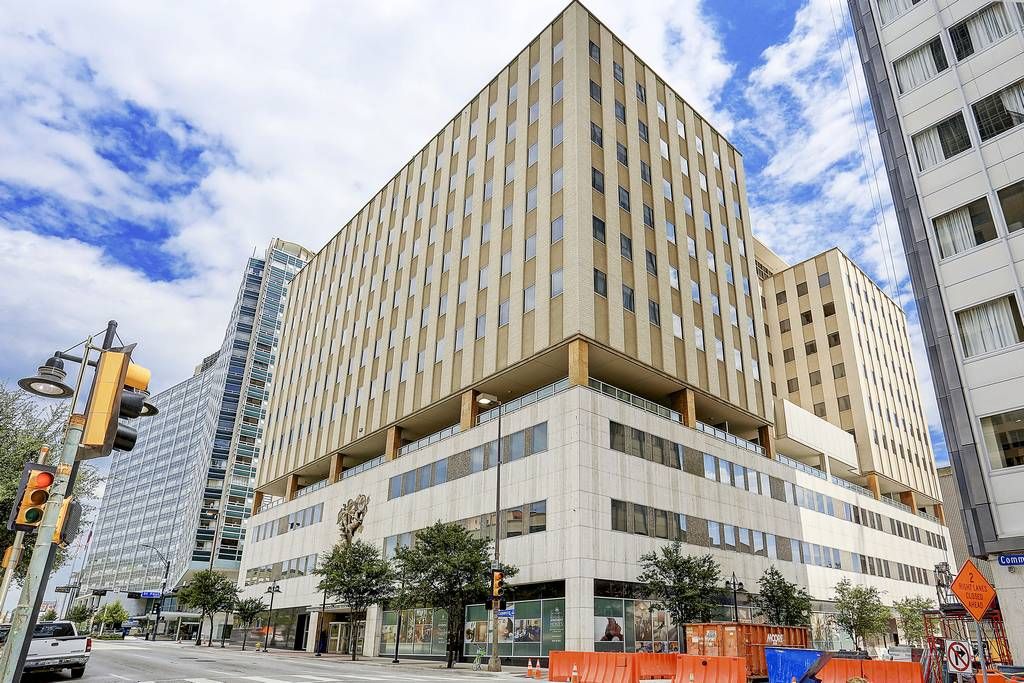 A multi-story building with a modern architectural design, featuring a flat facade and large windows.