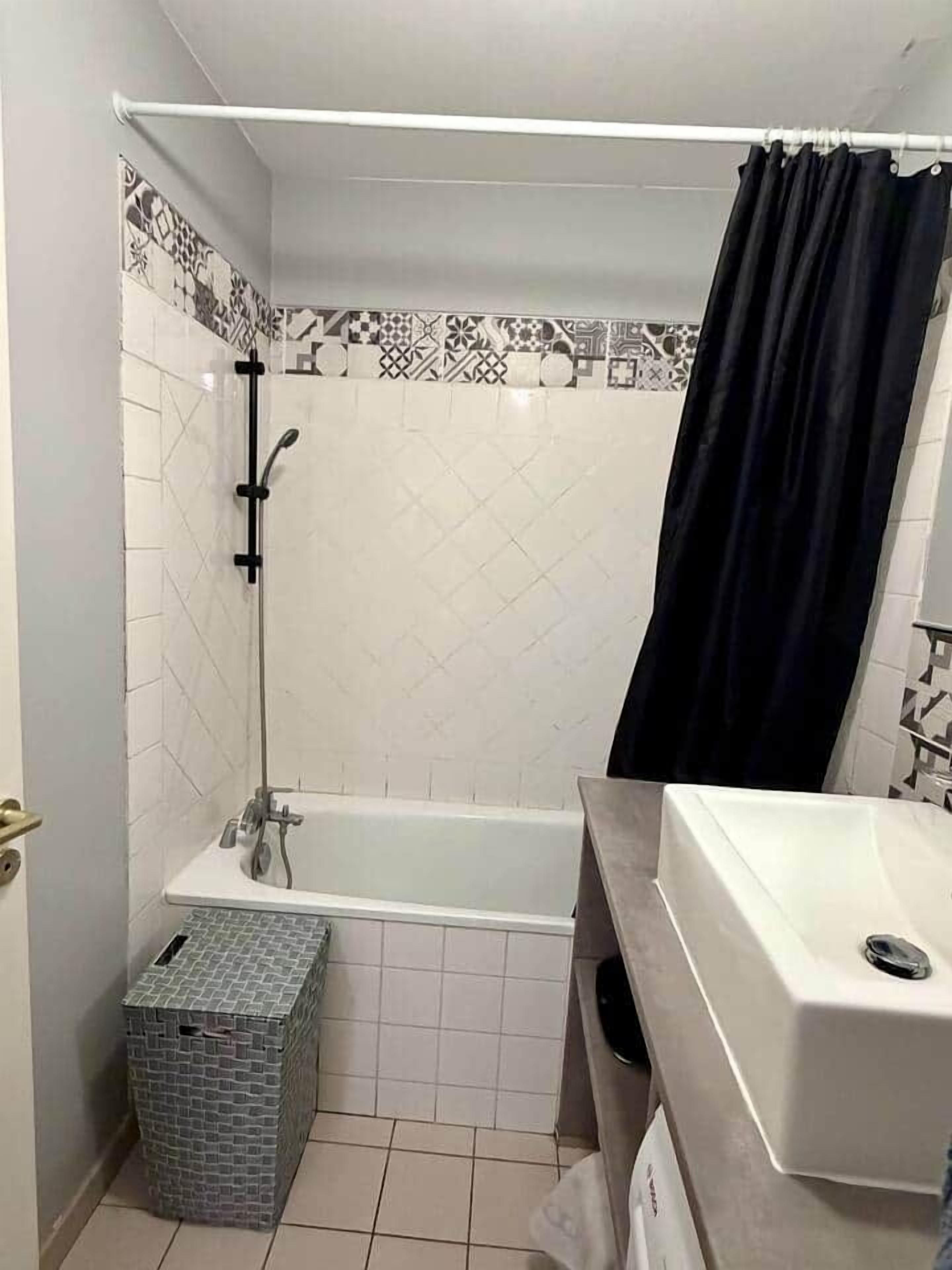 A bathroom with a bathtub, a shower, and a sink.