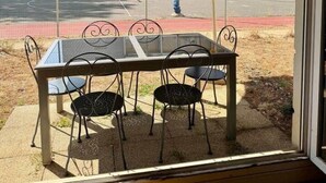 A table with chairs and a purple umbrella outside a window. - Le Chêne - Charming Apartment with a Garden (Lyon)