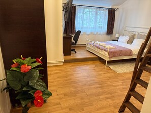 A bedroom with a bed, a desk, and a chair.