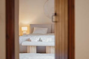Ein Schlafzimmer mit einem Bett, Kissen, einer Nachttischlampe und Holzboden.