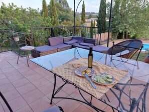 An outdoor patio with a glass table, a bottle of olive oil, and plates of food. - Maison chaleureuse de 5 chambres située en Provence idéale pour les familles (Brue-Auriac)