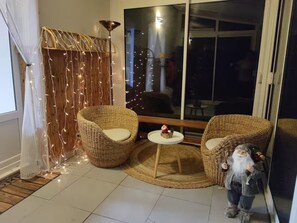 Um quarto aconchegante com cadeiras de vime, uma mesinha redonda e uma figura decorativa de gnomo.