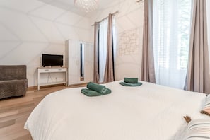 A bedroom with a bed, a TV on a stand, a wardrobe, and a sofa. - Holiday Home 'Le Mas De KItty' with Private Pool, Wi-Fi and Air Conditioning (Saint-Rémy-de-Provence)