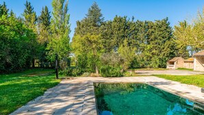 A rectangular swimming pool with clear blue water, surrounded by a paved deck and lush greenery. - Holiday Home 'Le Mas De KItty' with Private Pool, Wi-Fi and Air Conditioning (Saint-Rémy-de-Provence)