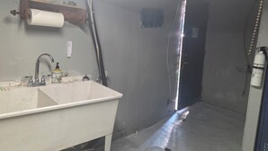 Un baño con lavamanos, inodoro, ducha y una pizarra en la pared.