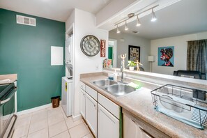 A modern kitchen with white cabinets, a double sink, and a stainless steel range hood. - Serene 1-bedroom apartment with AC in vibrant Dallas pool washer & Dryer, Wifi (Dallas)