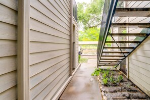 A narrow pathway leading to a staircase with a metal railing. - Serene 1-bedroom apartment with AC in vibrant Dallas pool washer & Dryer, Wifi (Dallas)