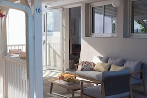 A room with a sofa, a table with fruit, and a sliding glass door.