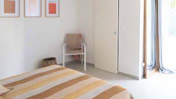 A bedroom with a bed, a chair, and a wardrobe.