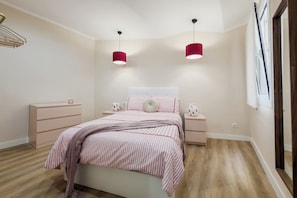 A bedroom with a bed, two bedside tables, a hanging light fixture, and a window with curtains. - Two-bedroom apartment in downtown Barcelona 2-2 (Barcelona)