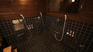 Un baño con pared de madera, suelo de baldosas negras y una ventana.