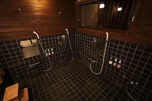 A bathroom with a wooden wall, black tiled floor, and a window. - Fujisan Lodge En (Minamitsuru-gun, Fujikawaguchiko machi,)