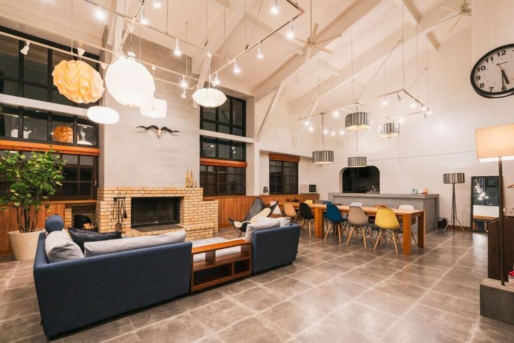 A spacious living area with a fireplace, a dining table with chairs, and a kitchen area.