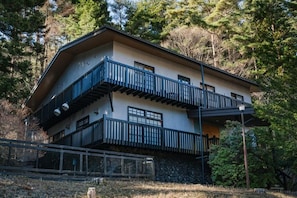 A two-story building with a balcony on the upper level, surrounded by trees. - Fujisan Lodge En (Minamitsuru-gun, Fujikawaguchiko machi,)