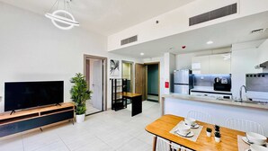 A modern kitchen with a built-in oven, a refrigerator, and a sink. - Premium Holiday Apartment at La Perla  (Dubai)