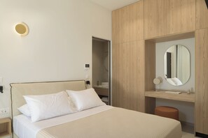Ein Hotelzimmer mit einem Bett, einem Nachttisch, einem Spiegel und einem Holzschrank.