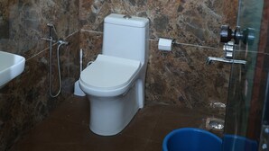 Un bagno con il water, una doccia e un lavandino.