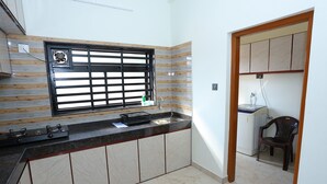 Una cucina con fornello a gas, lavandino e finestra con inferriata nera.