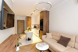 Ein modernes Wohnzimmer mit einer Couch, einem Couchtisch und einem Essbereich mit Tisch und Stühlen.