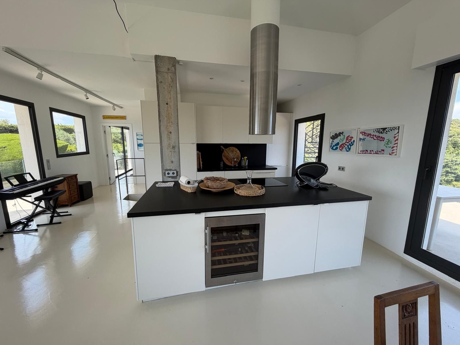 Una cocina moderna con una isla central, horno empotrado y un amplio ventanal que proporciona luz natural.
