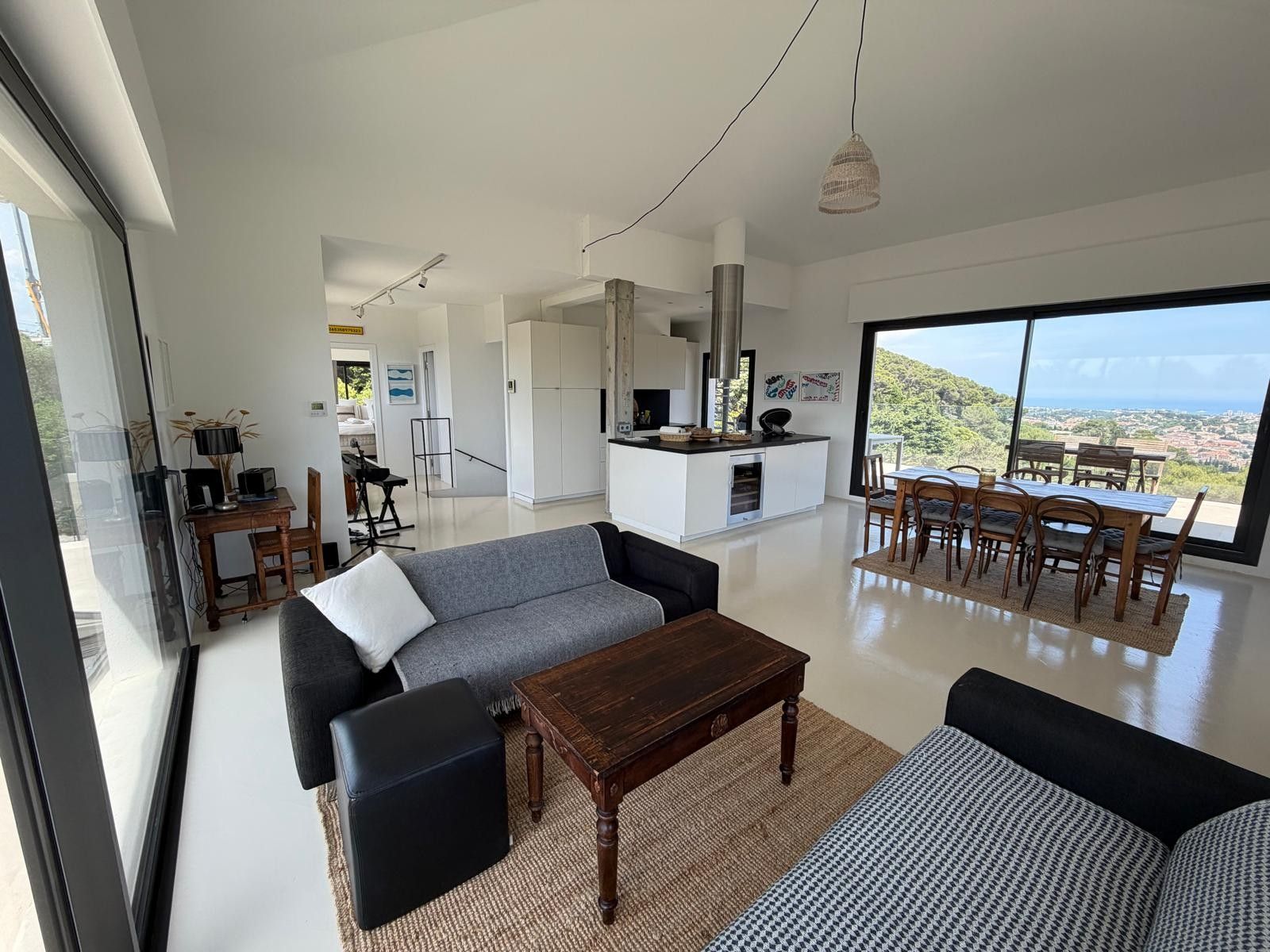 A modern living room with a sofa, a coffee table, and a dining area with chairs.