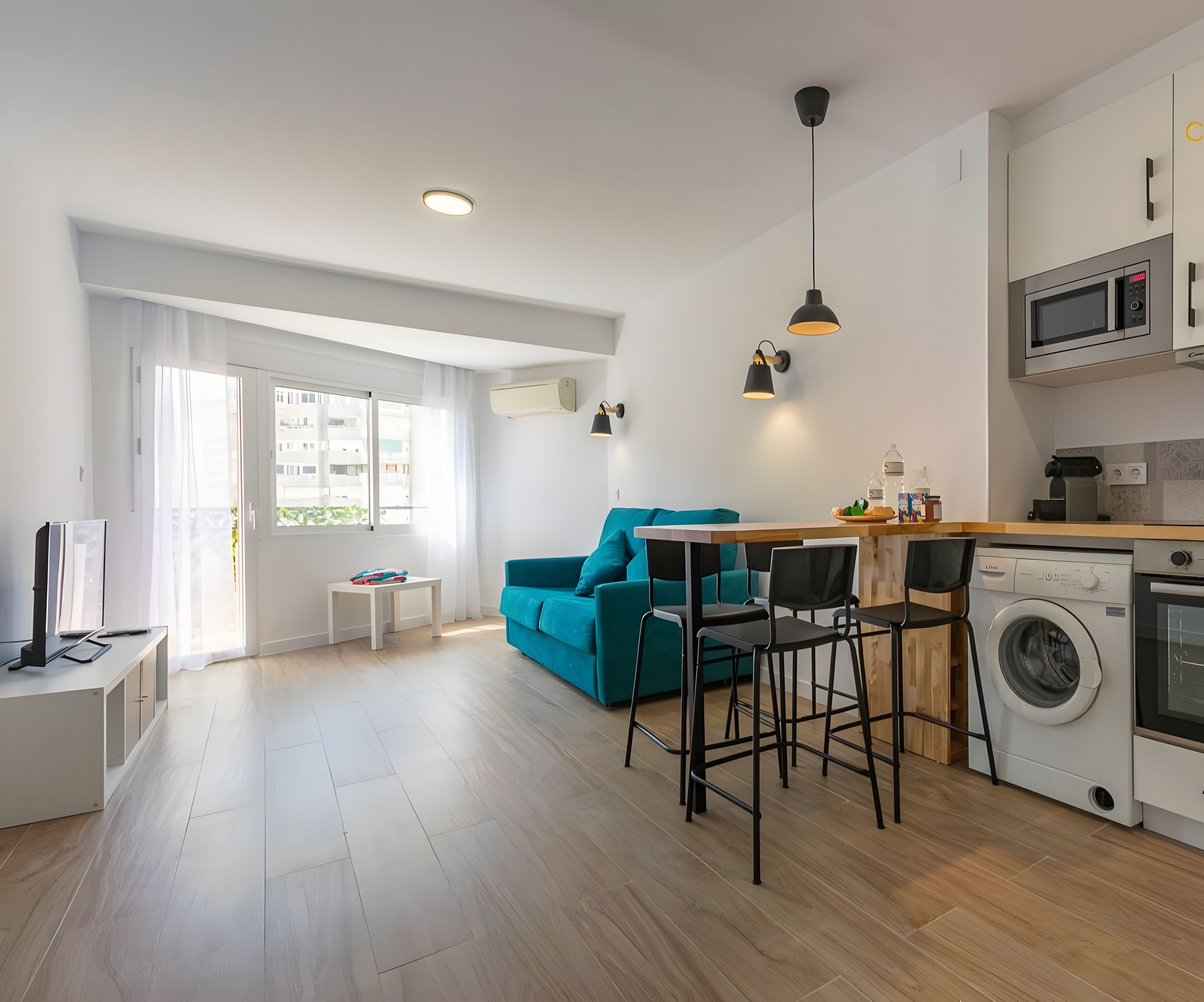 Un apartamento moderno con sala de estar, cocina y lavandería.