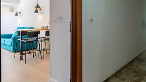 Un interno moderno con zona pranzo, un divano color petrolio e un pavimento in legno.