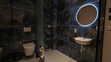 Un baño moderno con inodoro, bidé y lavamanos.